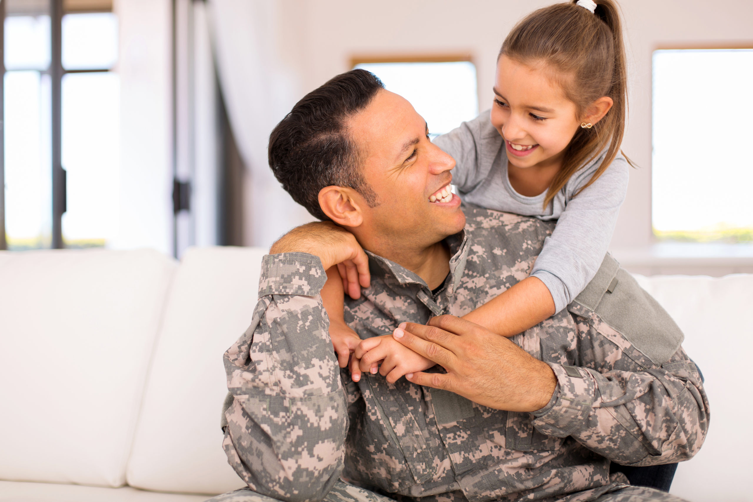 pretty little girl hugging her military father